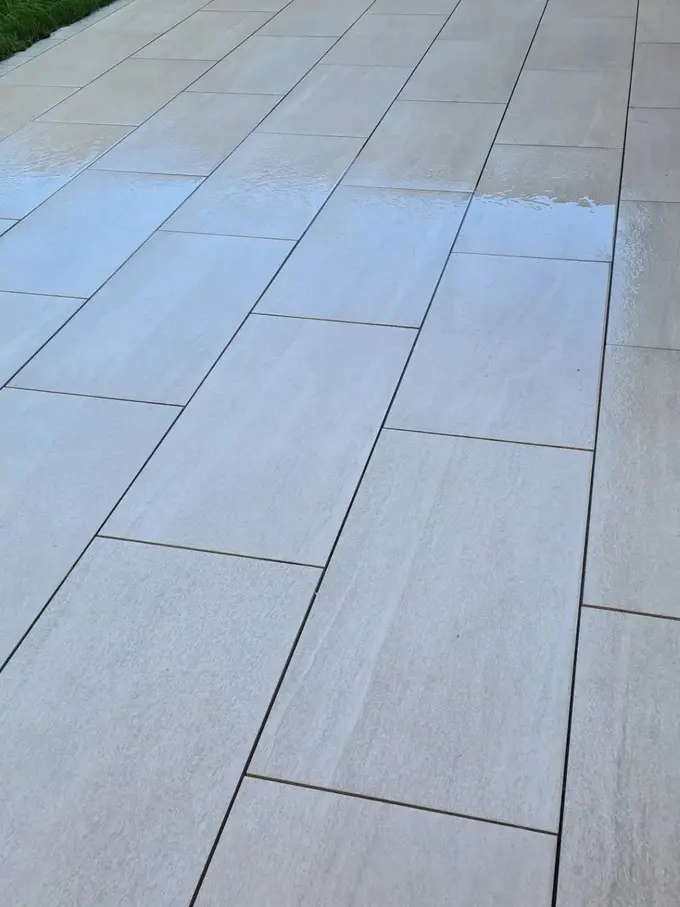 Grey porcelain patio soft washed clean of green algae