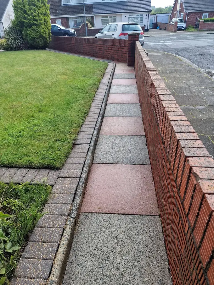 Block paving path cleaned between the lawn and garden wall