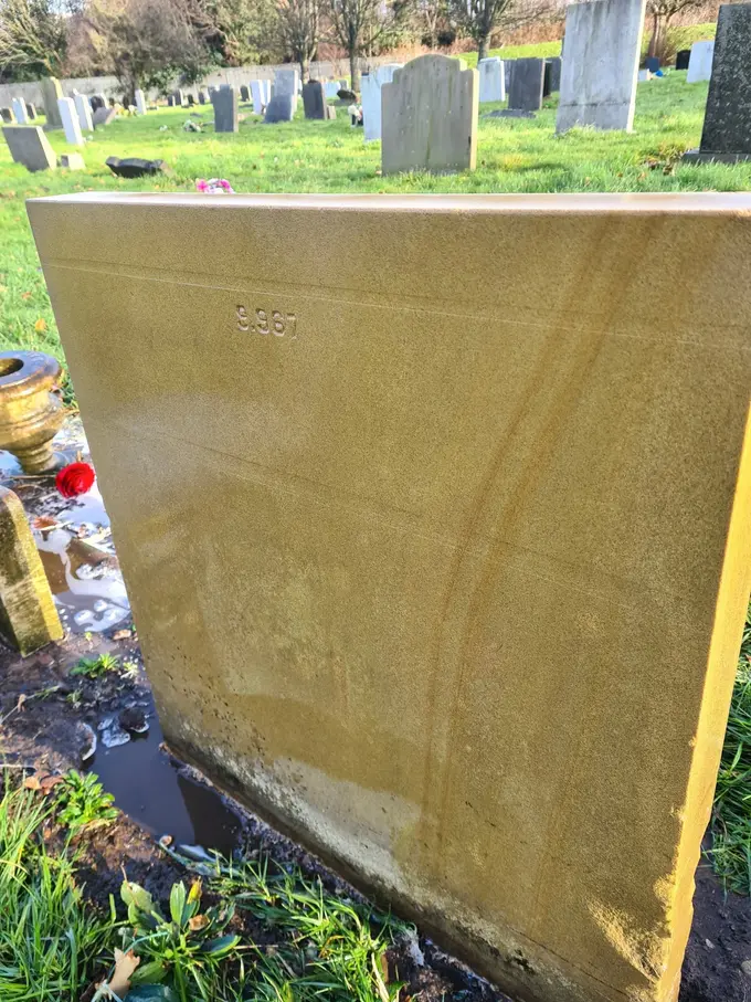 Weathered gravestone cleaned back to its natural colour