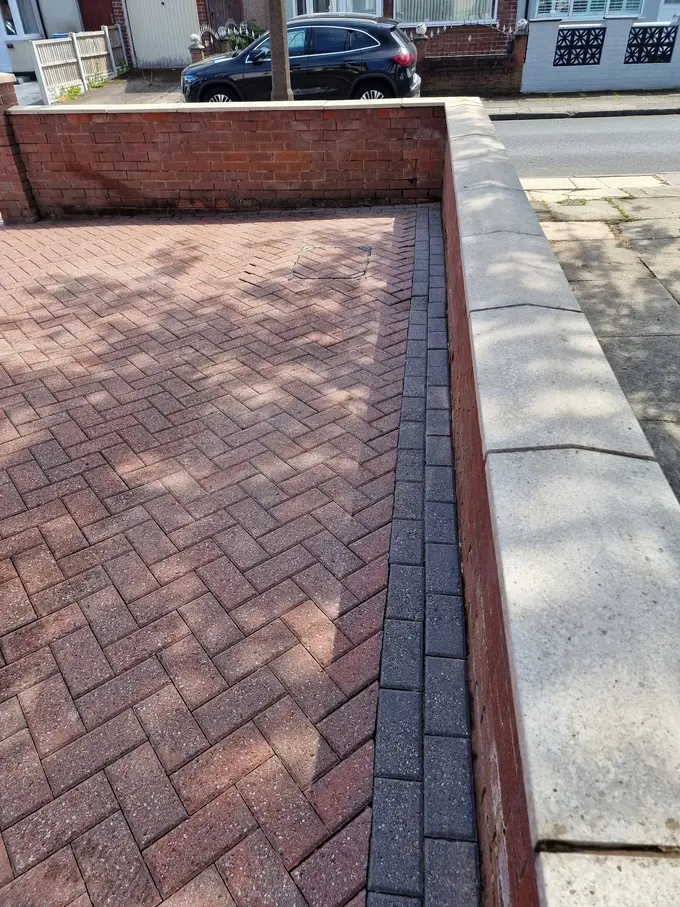 Red block paving driveway cleaned right to the kerb