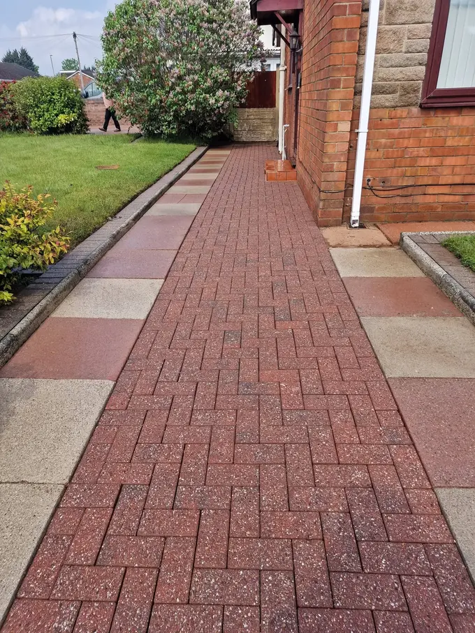 Red block paving path cleaned through the garden