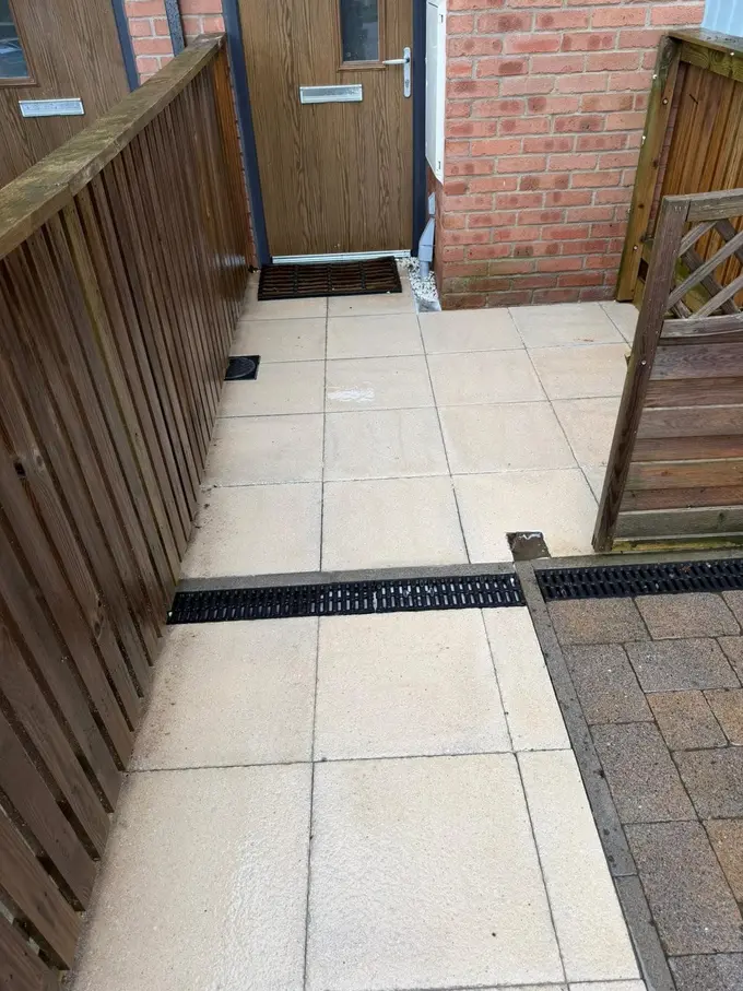 Flagged path and drainage channel jet washed clean of algae